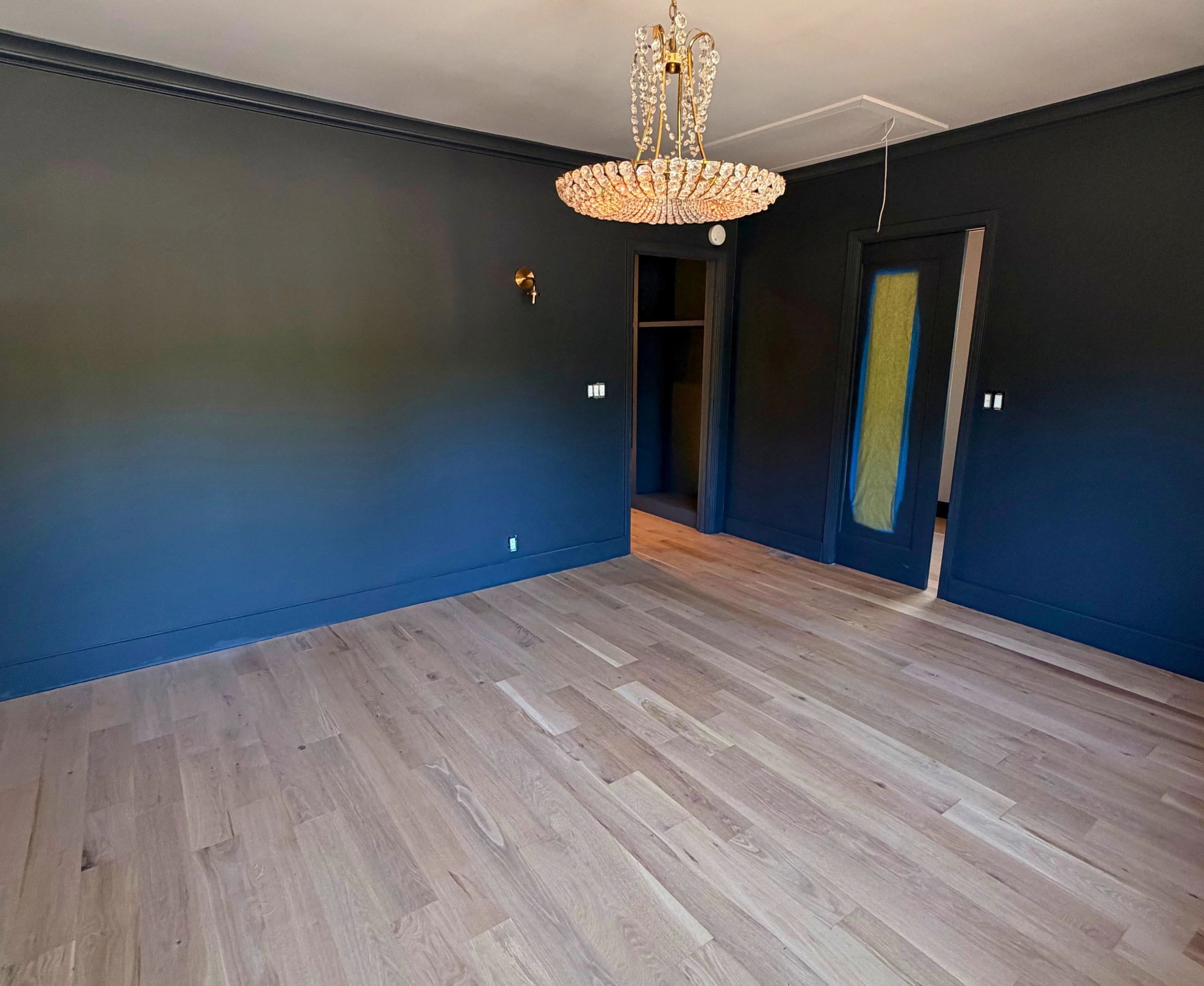Empty room with crystal chandelier and navy walls