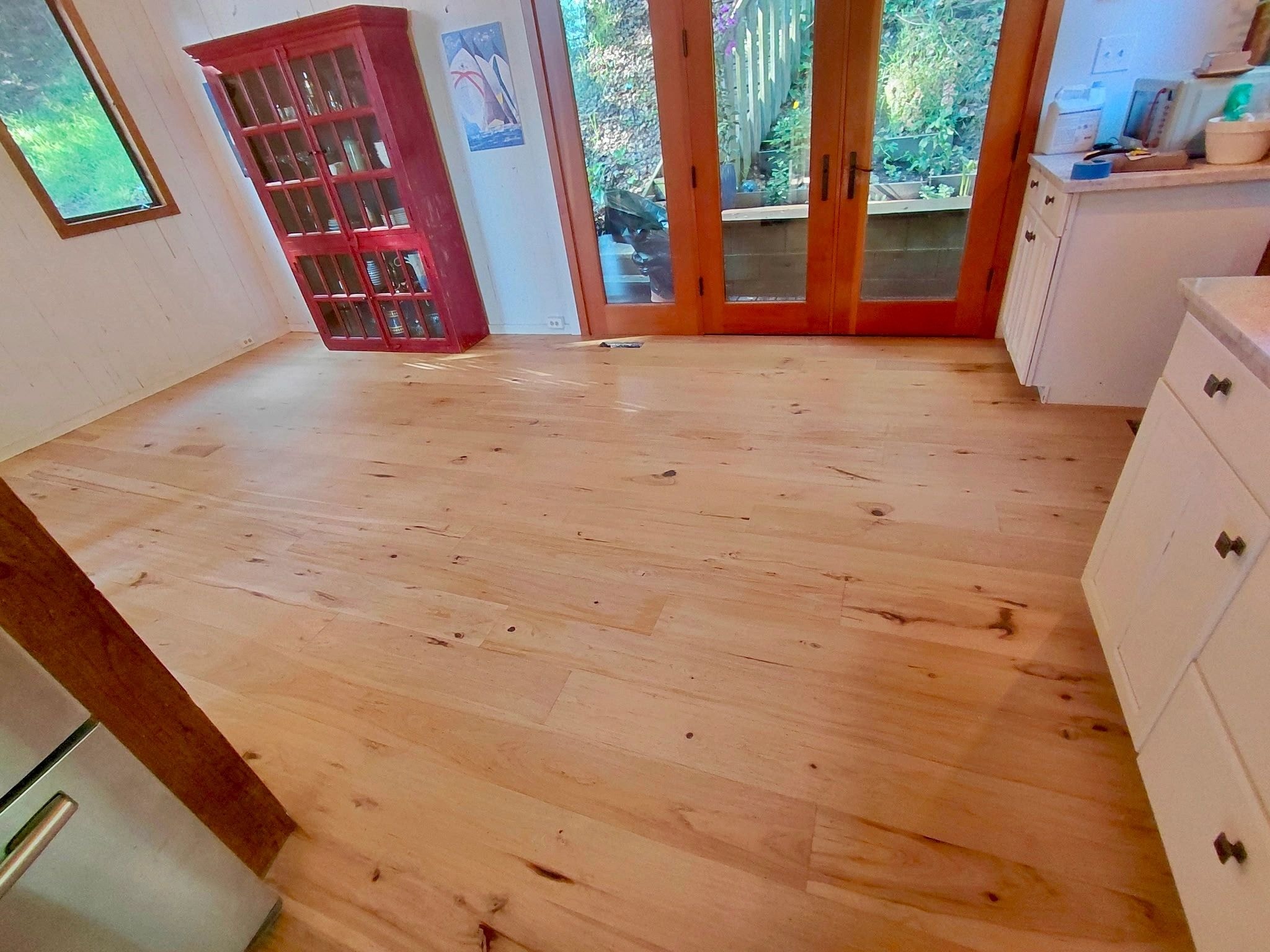 Spacious room with wooden floors and red cabinet doors