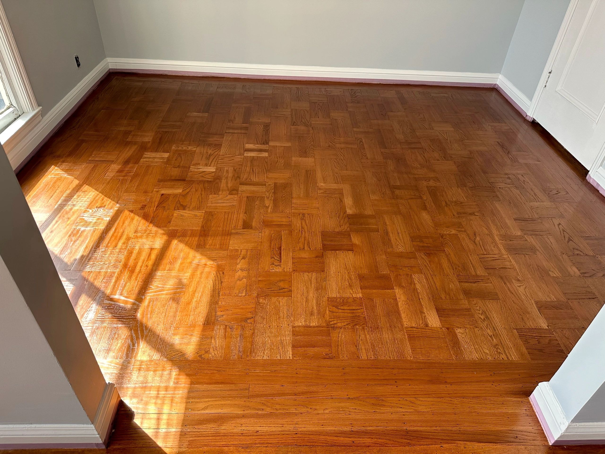Empty room herringbone wood floor in sunlight
